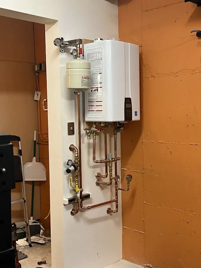 Plumbing technician inspecting water heater connections in Houston